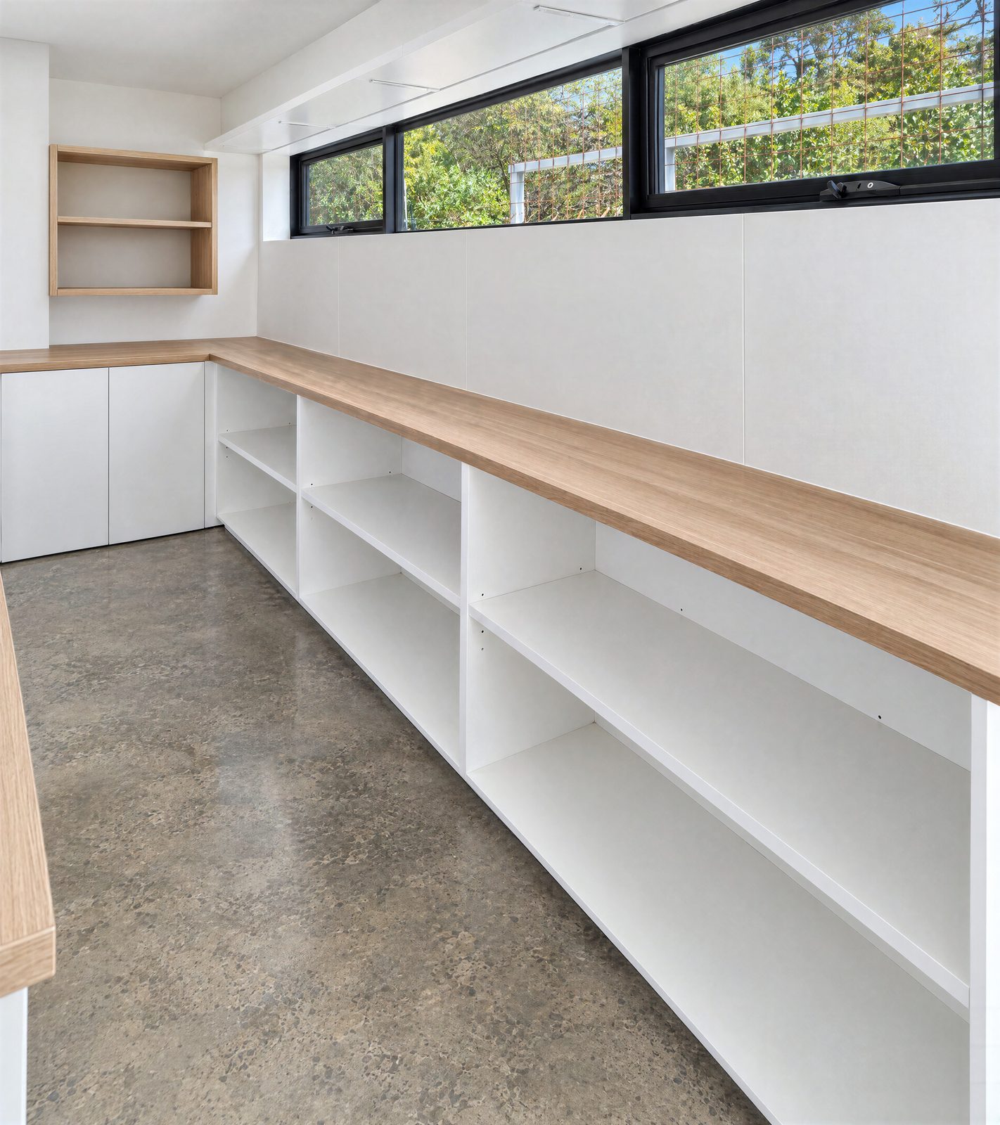 Long L-shaped garage bench with a timber-look top and open white shelving