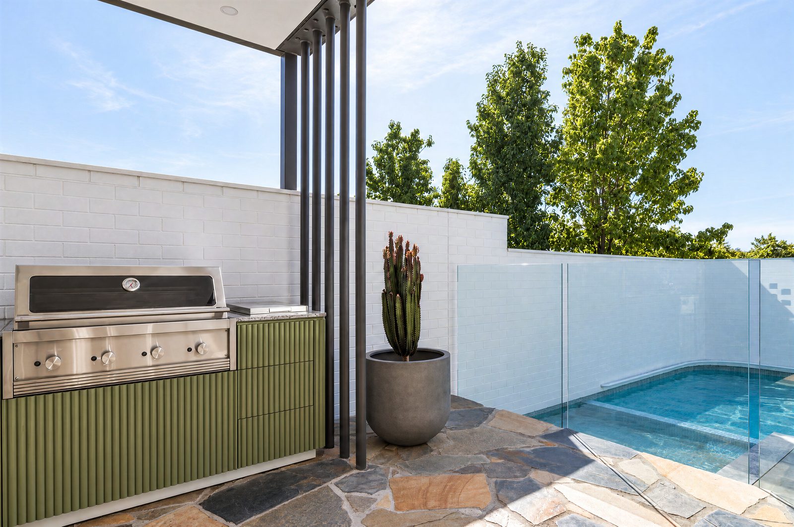 Outdoor kitchen with olive fluted cabinetry and a built-in barbecue