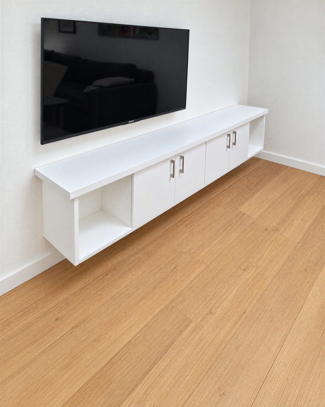 Floating white TV unit with open end cubbies and bar handles